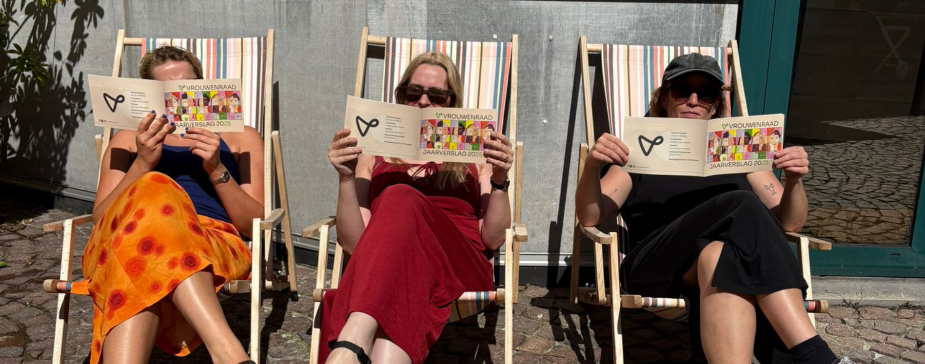 vrouwenraad team leest het jaarverslag op strandstoelen